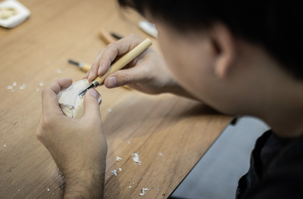 學生手上拿著雕刻刀正在工作中